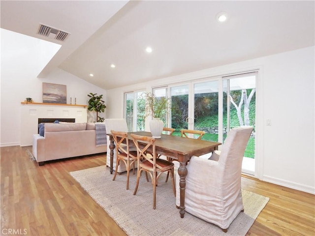 dining room featuring lofted ceiling and light wood-type flooring