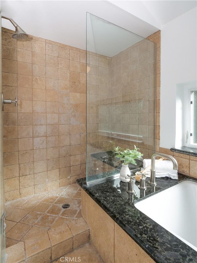 bathroom featuring a tile shower and sink