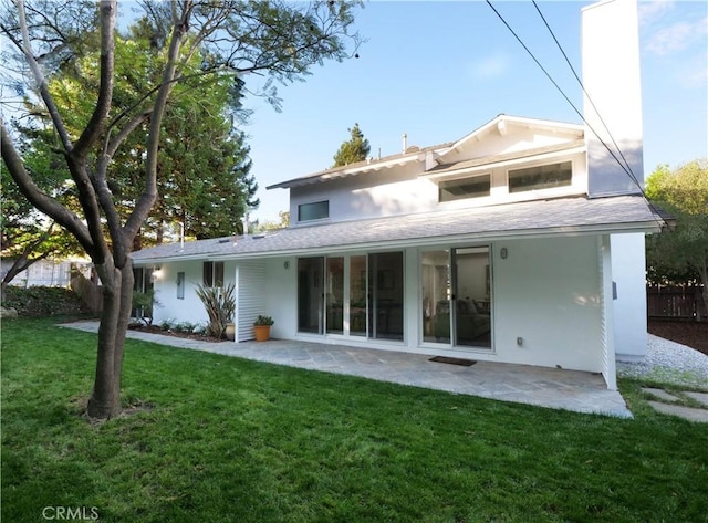 rear view of house with a patio area and a yard