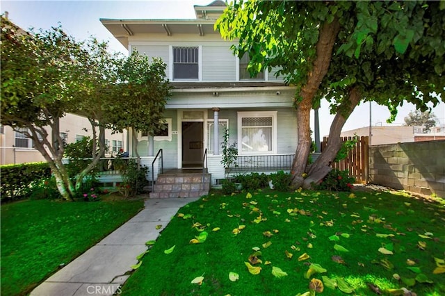 view of front of home with covered porch and a front yard