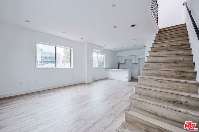 stairway with wood-type flooring and sink