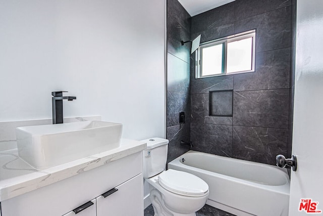 full bathroom featuring vanity, tiled shower / bath combo, and toilet