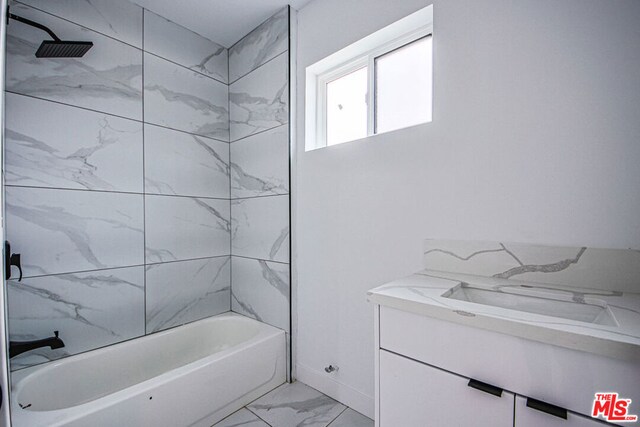 bathroom featuring vanity and tiled shower / bath