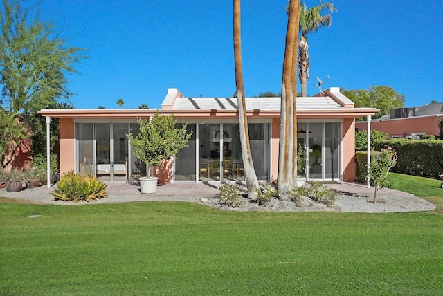 rear view of property with a yard and a sunroom