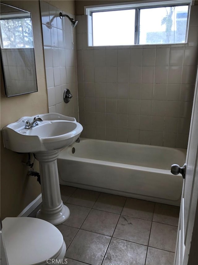 bathroom with tile patterned floors, tiled shower / bath combo, and toilet