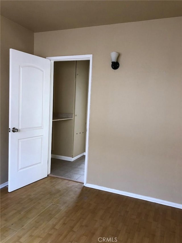 unfurnished bedroom with a closet and dark hardwood / wood-style flooring