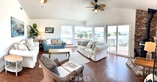 living room featuring dark hardwood / wood-style floors, ceiling fan, and vaulted ceiling