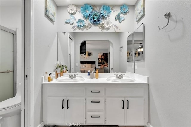 bathroom with vanity, toilet, walk in shower, and ceiling fan