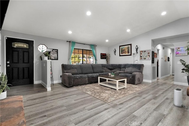 living room featuring light hardwood / wood-style floors and lofted ceiling