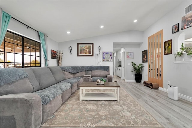 living room featuring light hardwood / wood-style floors and vaulted ceiling