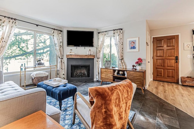 living room with a tiled fireplace and hardwood / wood-style floors