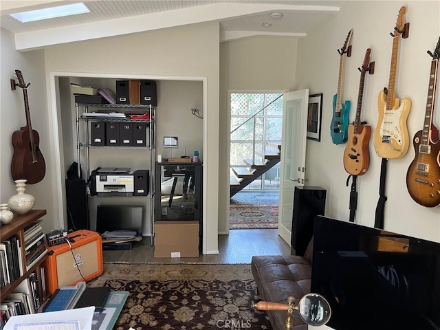 hallway featuring hardwood / wood-style floors and vaulted ceiling with skylight