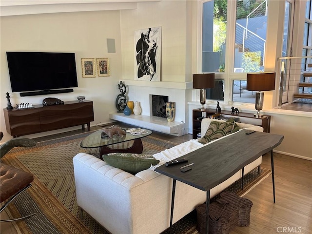 living room featuring hardwood / wood-style floors, lofted ceiling, and a fireplace