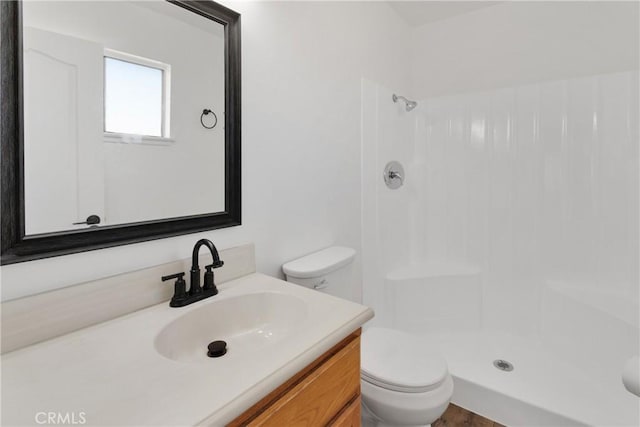 bathroom featuring vanity, toilet, and a shower