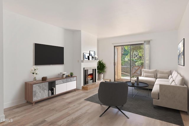 living room featuring a tile fireplace and light hardwood / wood-style floors