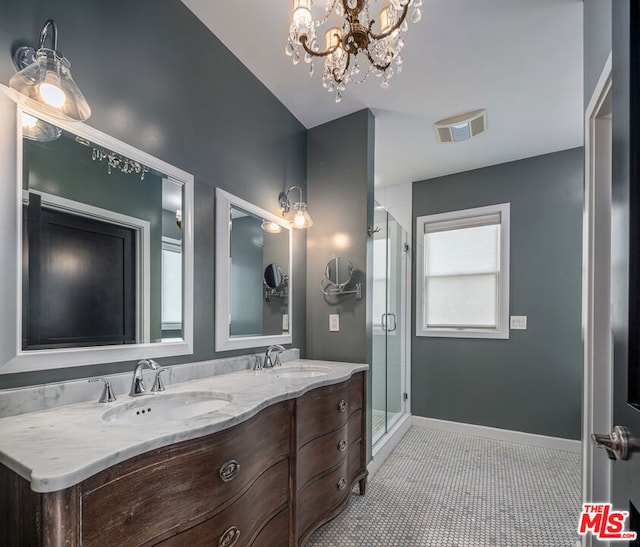 bathroom featuring a chandelier, vanity, a shower with shower door, and tile patterned flooring