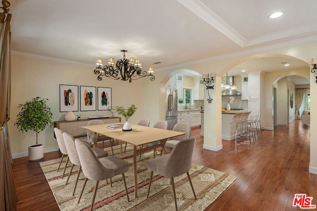 dining space featuring ornamental molding, dark wood-type flooring, and a chandelier