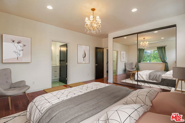 bedroom with wood-type flooring, ensuite bathroom, and an inviting chandelier