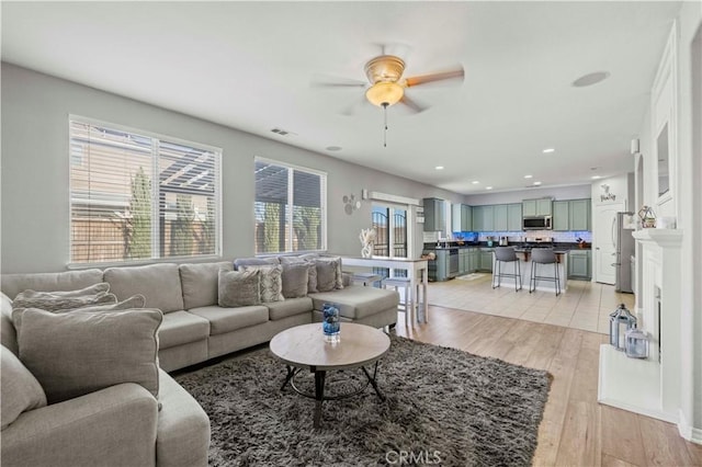 living room featuring light hardwood / wood-style floors and ceiling fan