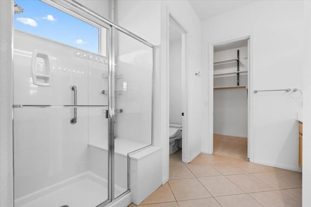 bathroom featuring tile patterned floors, toilet, and walk in shower