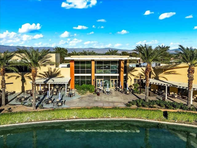 rear view of house with a mountain view and a patio