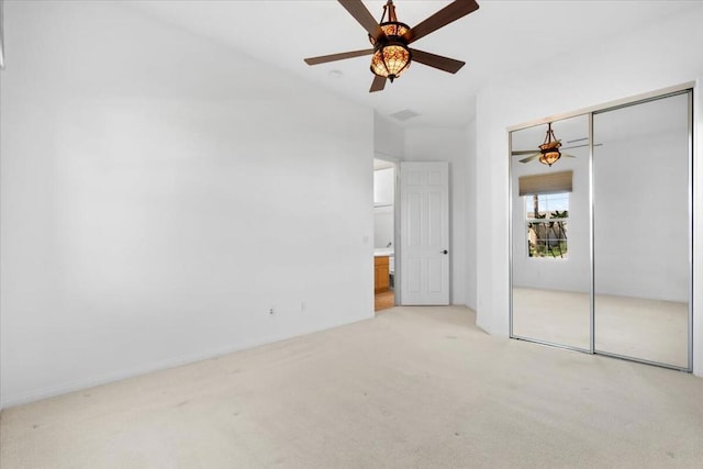 unfurnished bedroom with ceiling fan, light colored carpet, and a closet