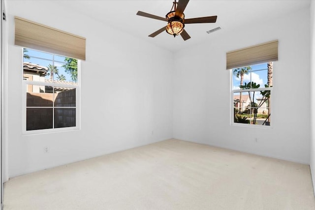 carpeted spare room with ceiling fan and a wealth of natural light