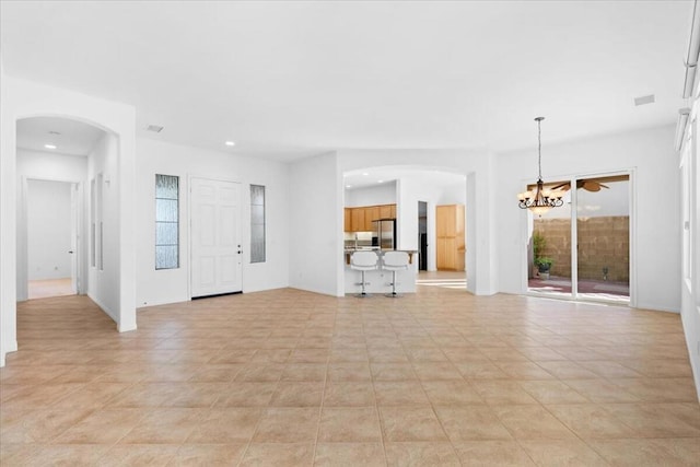 unfurnished living room with light tile patterned floors and a notable chandelier