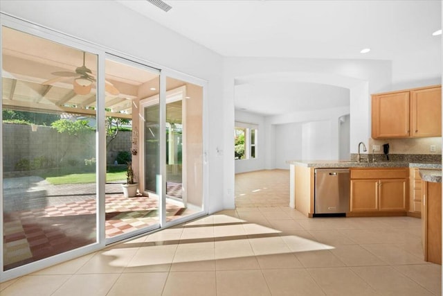 kitchen featuring sink, stainless steel dishwasher, ceiling fan, light tile patterned floors, and kitchen peninsula