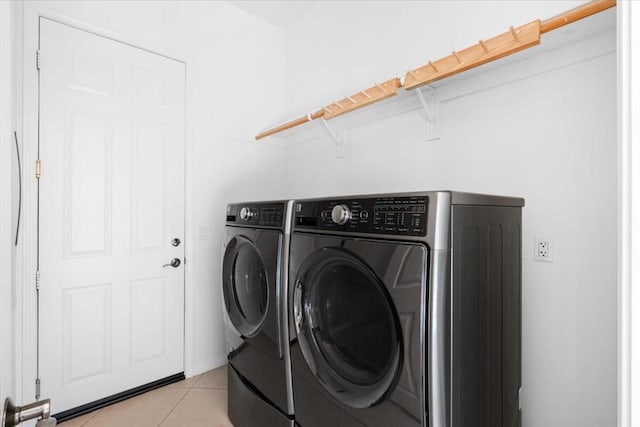 clothes washing area featuring light tile patterned floors and separate washer and dryer