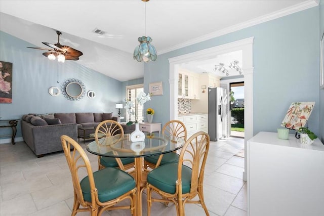 tiled dining area with vaulted ceiling, ceiling fan, and ornamental molding