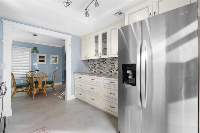 kitchen featuring light stone countertops, stainless steel refrigerator with ice dispenser, white cabinetry, and pendant lighting