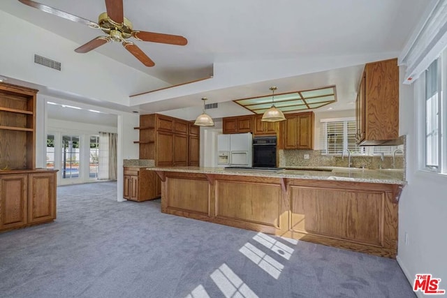 kitchen with kitchen peninsula, light colored carpet, pendant lighting, black oven, and white fridge with ice dispenser