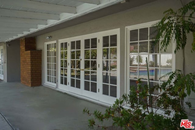 view of property exterior with a patio area and french doors