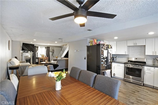 dining room with wood-type flooring, a textured ceiling, and ceiling fan