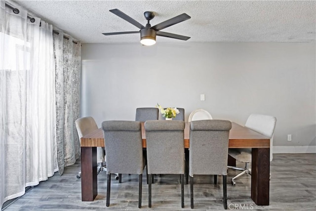 dining area featuring ceiling fan, dark hardwood / wood-style flooring, and a textured ceiling