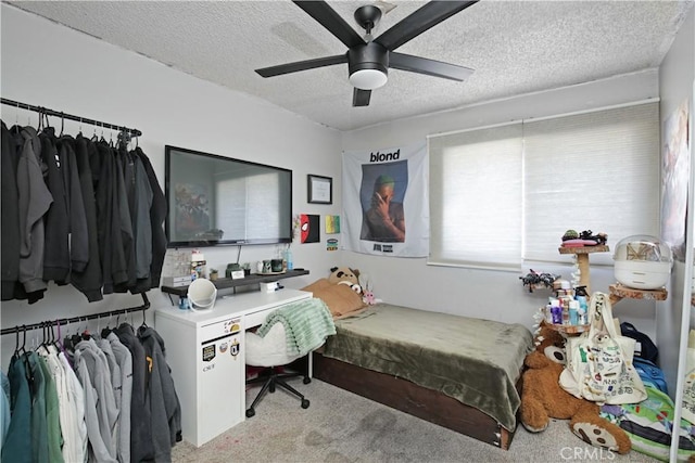 bedroom with a textured ceiling, light colored carpet, and ceiling fan