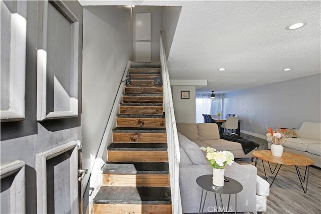 stairs featuring hardwood / wood-style floors and a textured ceiling