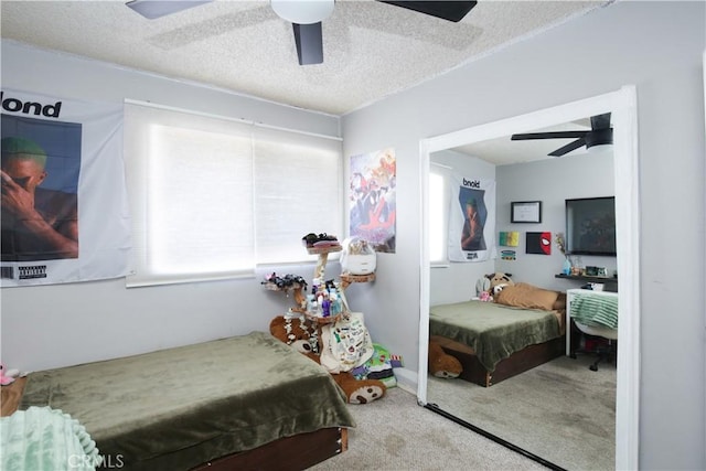 bedroom with light carpet, multiple windows, a textured ceiling, and ceiling fan