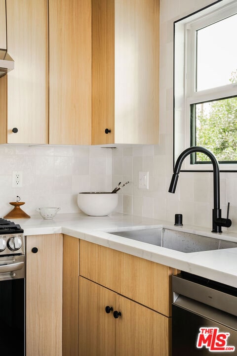 kitchen with tasteful backsplash, extractor fan, sink, stainless steel range oven, and black dishwasher