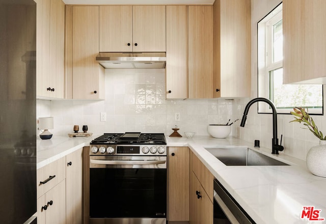 kitchen with backsplash, sink, light brown cabinets, and stainless steel gas range