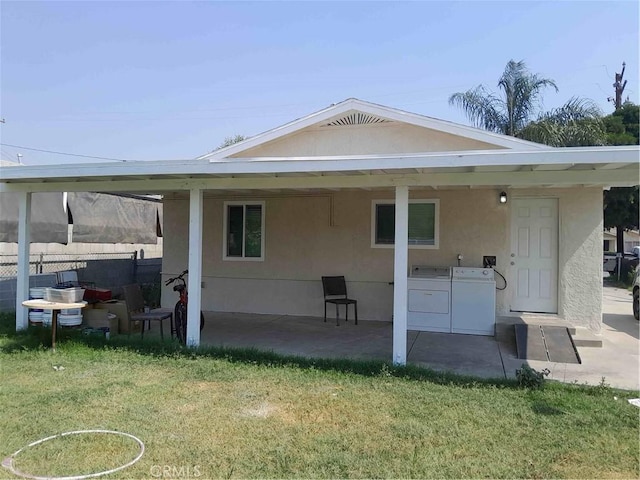 back of property with a lawn, a patio, and washing machine and clothes dryer