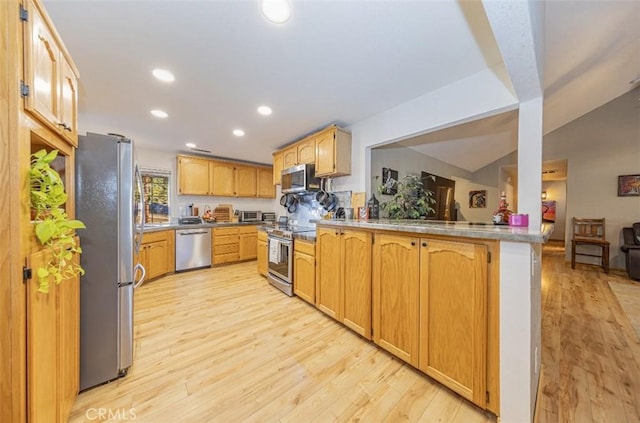 kitchen with kitchen peninsula, light hardwood / wood-style floors, lofted ceiling, and appliances with stainless steel finishes