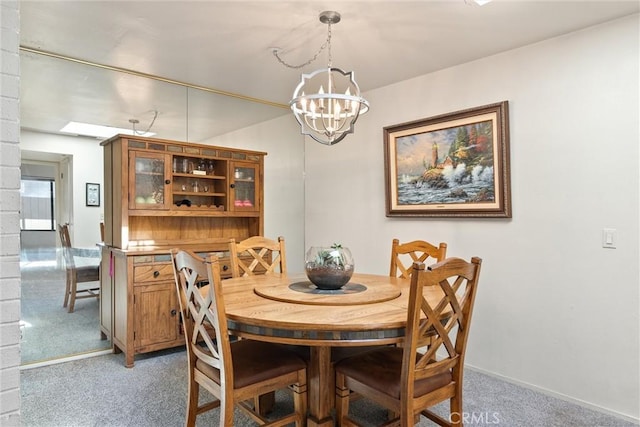 dining space featuring light carpet and a chandelier