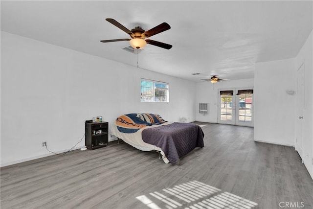 bedroom featuring ceiling fan, light hardwood / wood-style floors, and french doors