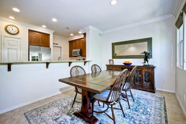 dining area featuring crown molding and light tile patterned flooring