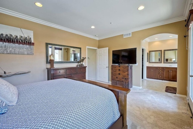 bedroom featuring ensuite bathroom, light colored carpet, and ornamental molding