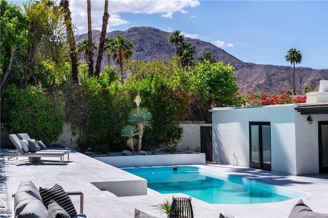 view of swimming pool featuring a mountain view and a patio