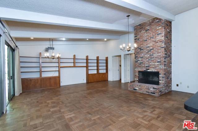 unfurnished living room with an inviting chandelier, dark parquet floors, beamed ceiling, a textured ceiling, and a fireplace