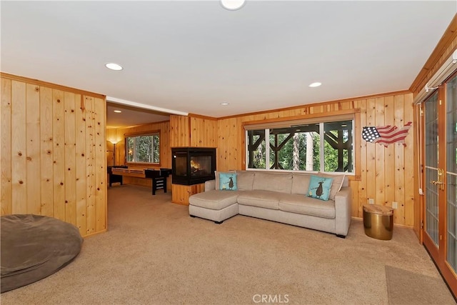 carpeted living room with wood walls, pool table, and crown molding